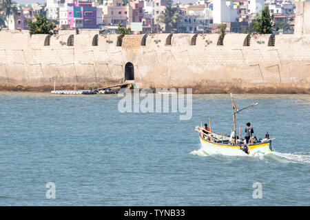 Diu und Daman, Gujarat, Indien - ca. 2019: Boot nähert sich die Steinmauer eines Schlosses im Meer in Diu Gujarat Indien. Das blaue Meer, die Hell Dekor Stockfoto