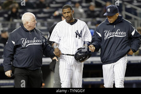 New York Yankees Manager Joe Girardi und Steve Donohue zu Fuß zur ersten Base mit Eduardo Nunez, nachdem er durch einen Pitch im zweiten Inning gegen die Baltimore Orioles im Yankee Stadium in New York City am 12. April 2013 getroffen wird. UPI/John angelillo Stockfoto