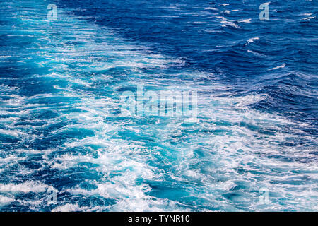 Ein Band der Wellen im Meer, das vom Schiff war. Es ist schön mit blauem Hintergrund und tuquoise Meerwasser, Furteventura, Kanarischen Inseln. Stockfoto