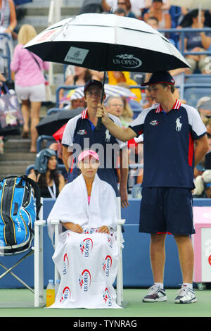 Jie Zheng China hält trocken wie Regen beginnt wieder zu fallen, die Aussetzung gegen Venus Williams (USA), bei den US Open Championship am USTA Billie Jean King National Tennis Center am 28. August 2013 in New York City. UPI Foto/Monika Graff Stockfoto