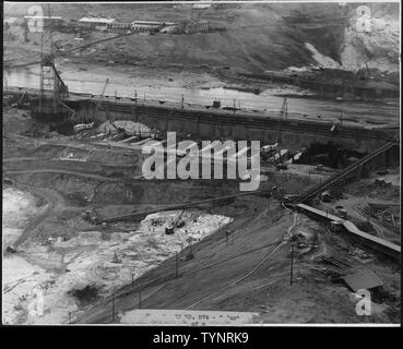 Blick in das Innere von West fangdamms zeigt schwere Holz Aussteifung über das Feld für besondere Struktur vom Typ in den Aushub für den Block 40. East Side fangdamms über den Fluss, die Spannweite der Hängebrücke für Aggregate Förder- und M.W.A.K. Geschäfte auf der linken Seite.; Umfang und Inhalt: Foto aus Band 2 einer Reihe von Fotoalben Dokumentation der Bau des Grand Coulee Dam und die damit verbundenen Arbeiten auf dem Columbia Basin Project. Stockfoto