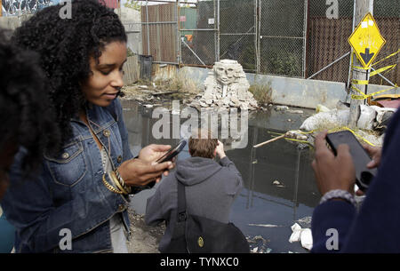 Die Leute, um zu sehen "keinen Turn Unstoned", ein 1/36 scale Nachbildung der Großen Sphinx von Gizeh aus zertrümmerte störende cinderblocks von britischen Street Artist Banksy in Queens in der Nähe von Citi Field in New York City Erstellt am 22. Oktober 2013 vorgenommen. Banksy ist ein Pseudonym in England Graffiti Künstler, politischer Aktivist, Regisseur und Maler. Seine satirischen Street Art und subversive Epigramme kombinieren dunkle Humor mit Graffiti in einem unverwechselbaren Schablonieren Technik getan. UPI/John angelillo Stockfoto