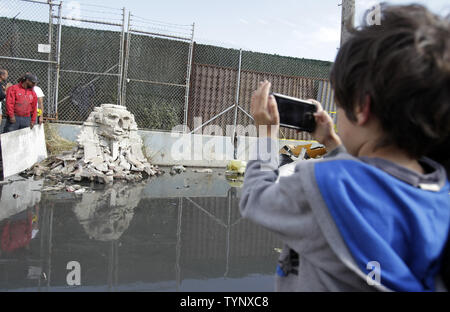 Ein Kind nimmt ein Bild von "No Turn Unstoned", ein 1/36 scale Nachbildung der Großen Sphinx von Gizeh aus zertrümmerte störende cinderblocks von britischen Street Artist Banksy in Queens in der Nähe von Citi Field in New York City Erstellt am 22. Oktober 2013 vorgenommen. Banksy ist ein Pseudonym in England Graffiti Künstler, politischer Aktivist, Regisseur und Maler. Seine satirischen Street Art und subversive Epigramme kombinieren dunkle Humor mit Graffiti in einem unverwechselbaren Schablonieren Technik getan. UPI/John angelillo Stockfoto