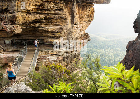 Katoomba, New South Wales, Australien - 13. Februar 2019: Brücke Bildung drei Schwestern mit Wanderer in der sunshined Tal auf der Suche nach Rock Stockfoto