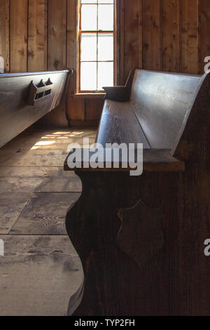 Leere Kirche Pew in vertikaler Ausrichtung. Altmodische Holz Kirche pew in kleinen ländlichen Amerikanischen Kirche. Stockfoto