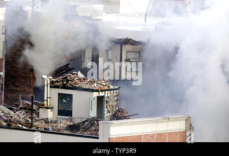 NYPD Feuerwehr weiterhin ein Feuer, wo die Innenwand eines Gebäude an der Szene von 2 eingestürzten Gebäuden an 116 St und der Park Avenue in New York City am 13. März 2014 ausgesetzt ist, zu kämpfen. Mindestens 7 Menschen wurden getötet und mehrere weitere verletzt, wenn ein Leck in einer Gasleitung zu einer Explosion, die zwei Manhattan Gebäude am 12. März 2014 eingeebnet. UPI/John angelillo Stockfoto