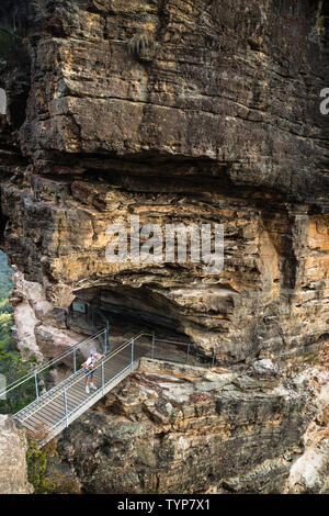 Katoomba, New South Wales, Australien - 13. Februar 2019: Brücke Bildung drei Schwestern mit Wanderer zu Rock, Vertikal, Katoomba, New South Wales, Australien Stockfoto