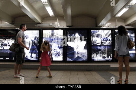 Die Menschen halten an einer Gruppe von Marilyn Monroe Fotos aufgenommen von Fotograf Sam Shaw, das auf dem Display in einer New Yorker U-Bahn am 7. August 2014 werden zu suchen. Fotograf Sam Shaw ist für seinen ikonischen Bilder von Stars wie Marilyn Monroe und Marlon Brando erinnert. Über 50 Jahre nach ihrem Tod, Marilyn Monroe ist noch immer so viel eine amerikanische Ikone, wie sie war in den 50er und 60er Jahren. UPI/John angelillo Stockfoto