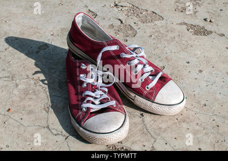 Paar verschlissen vintage Red Old canvas Turnschuhe an außerhalb der Betonoberfläche Stockfoto