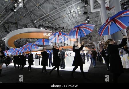 Eine Linie von Mädchen sonnenschirme Durchführung Spaziergang unter den Autos, die auf der 2015 New York International Auto Show in New York City am 1. April 2015. Die ersten New York Auto Show im Jahr 1900 statt und es war das erste Auto Show je in Nordamerika statt. Über 1 Millionen Besucher erwartet, um die Show zu besuchen. Foto von John angelillo/UPI Stockfoto