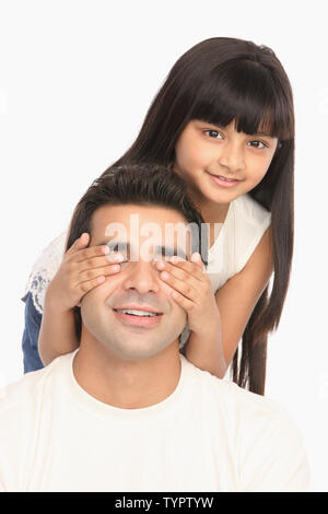 Indische Mädchen für Vaters Augen von hinten und lächelnd Stockfoto