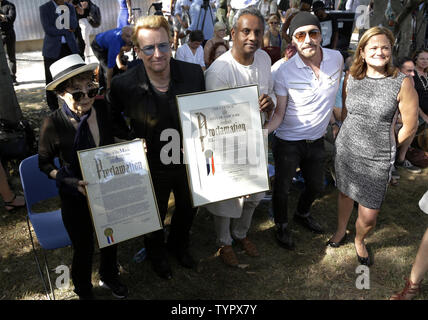 Yoko Ono, Bono, Edge, Amnesty International Generalsekretär Salil Shetty und New York City Rat Lautsprecher Melissa Mark-Viverito stehen zusammen, bevor Sie enthüllen ein Riese 24' x 10' Wandteppich zu Ehren John Lennon im Ellis Island Immigration Museum in New York City am 29. Juli 2015. Die Tapestry wurde durch Kunst für Amnesty Gründer Bill Shipsey beauftragt, als Dank an Ono für Amnesty International die Rechte an Coverversionen von Lennon's Post-Beatles Songs im Jahr 2004, so dass Amnesty über 5 Mio. $ in den Abgaben seit zu erhöhen. Bono, Edge und Musik Business Stockfoto