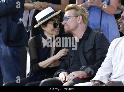 Bono von U2 und Yoko Ono zusammen sitzen und auf die Lautsprecher zu hören, bevor Sie einen riesigen 24' x 10' Wandteppich zu Ehren John Lennon in der Gegenwart Amnesty International Generalsekretär Salil Shetty im Ellis Island Immigration Museum in New York City am 29. Juli 2015 vorstellen. Die Tapestry wurde durch Kunst für Amnesty Gründer Bill Shipsey beauftragt, als Dank an Ono für Amnesty International die Rechte an Coverversionen von Lennon's Post-Beatles Songs im Jahr 2004, so dass Amnesty über 5 Mio. $ in den Abgaben seit zu erhöhen. Bono, Edge und Musik business impresario Jimmy Stockfoto