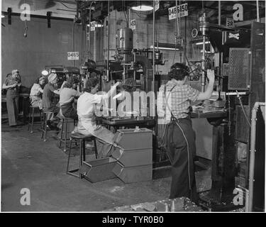 Frauen Mann Amerikas Maschinen in einem Westküste Flugzeug Fabrik, wo die Swing shift von Bohrmaschine Betreiber fast ausschließlich aus Frauen besteht. Stockfoto