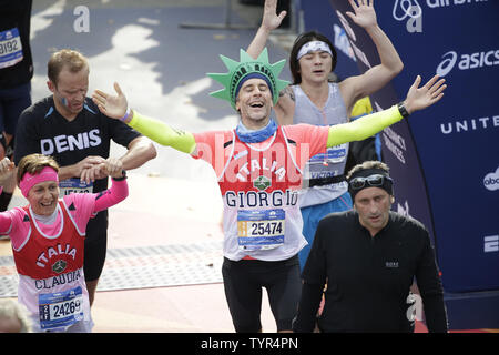 Läufer reagieren und feiern, als sie die Ziellinie an der NYRR TCS New York City Marathon in New York City am 1. November 2015. 50.000 Läufer aus den Big Apple und rund um die Welt rennen durch den fünf Bezirken auf einem Kurs, der von der Verrazano Bridge vor dem Überqueren der Ziellinie durch Taverne auf dem Grün im Central Park. Foto von John angelillo/UPI Stockfoto