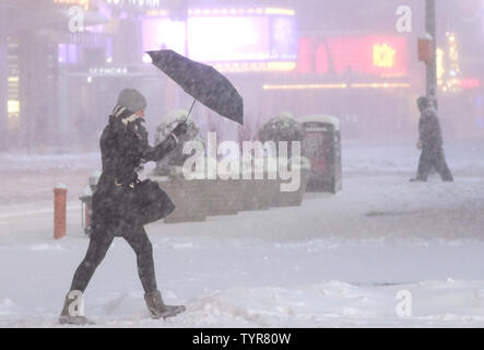 Eine Frau mit einem Regenschirm Wanderungen durch den Schnee in Times Square als gefährlich Sturm Jonas lähmende Schnee bringt, starker Vereisung und Blizzard Bedingungen in New York City am 23. Januar 2016. Mehr als 85 Millionen Menschen in mindestens 20 Staaten Sturmwarnungen oder Empfehlungen. Wetter Prediction Center schätzungsweise mehr als 2 Meter Schnee für Washington, ein Fuß zu 18 Zoll für Philadelphia und acht Zoll zu einem Fuß in New York. Foto von John angelillo/UPI Stockfoto