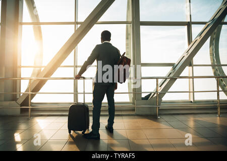 Geschäftsmann am Flughafen Terminal Gate suchen Durch das Fenster Stockfoto