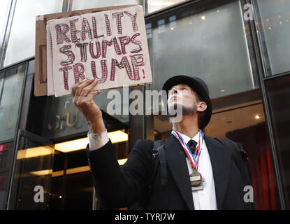 Die Demonstranten halten Schilder, wie sie im Trump Tower am 19. Oktober 2016 in New York City versammeln. Eine große Gruppe von meist Frauen zeigte sich außerhalb Trump Tower an der Fifth Avenue und inszenierten einen Protest gegen republikanische Präsidentenkandidat Donald Trump für die Sprache, die er in einer Bombe hot mic Band, die am vergangenen Freitag bekannt geworden und hat die Präsidentenwahlen nur wenige Wochen vor dem Wahltag verordnungdrogeverkäufen verwendet. Foto von John angelillo/UPI Stockfoto