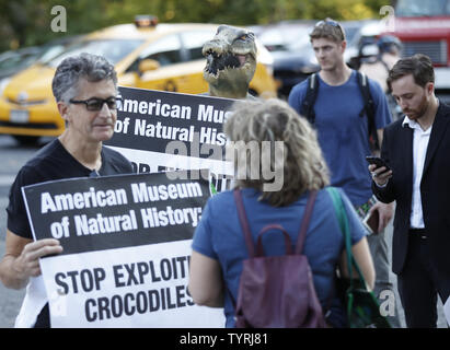 Die Demonstranten tragen Krokodil Masken halten Schilder und ein Protest Stufe Seite des American Museum of Natural History am 19. Oktober 2016 in New York City. In Blazer gekleidet und tragen neben zwei Krokodil krokodil Masken, Skulpturen, zwei Leute für die ethische Behandlung der Tiere (PETA) Anhänger protestierten forderten ein Ende des Museums "Crocs: Alte Raubtiere in einer modernen Welt' Exponat als Gäste für die 23. jährlichen Familienfest Geldbeschaffer angekommen. Foto von John angelillo/UPI Stockfoto