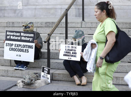 Die Demonstranten tragen Krokodil Masken halten Schilder und ein Protest Stufe Seite des American Museum of Natural History am 19. Oktober 2016 in New York City. In Blazer gekleidet und tragen neben zwei Krokodil krokodil Masken, Skulpturen, zwei Leute für die ethische Behandlung der Tiere (PETA) Anhänger protestierten forderten ein Ende des Museums "Crocs: Alte Raubtiere in einer modernen Welt' Exponat als Gäste für die 23. jährlichen Familienfest Geldbeschaffer angekommen. Foto von John angelillo/UPI Stockfoto