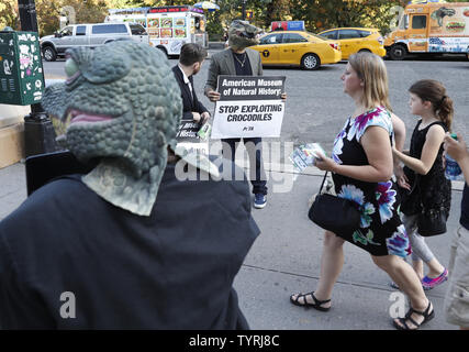 Die Demonstranten tragen Krokodil Masken halten Schilder und ein Protest Stufe Seite des American Museum of Natural History am 19. Oktober 2016 in New York City. In Blazer gekleidet und tragen neben zwei Krokodil krokodil Masken, Skulpturen, zwei Leute für die ethische Behandlung der Tiere (PETA) Anhänger protestierten forderten ein Ende des Museums "Crocs: Alte Raubtiere in einer modernen Welt' Exponat als Gäste für die 23. jährlichen Familienfest Geldbeschaffer angekommen. Foto von John angelillo/UPI Stockfoto