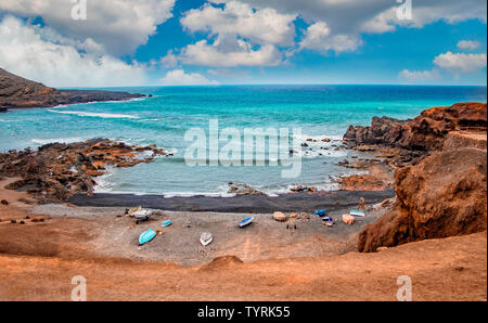 Die schwarzen vulkanischen Strand mit Meerblick bucht. Das Wasser ist türkisblau und klar und blauen Himmel im Hintergrund, El Golfo, Lanzarote, Kanarische Inseln, Spanien. Stockfoto