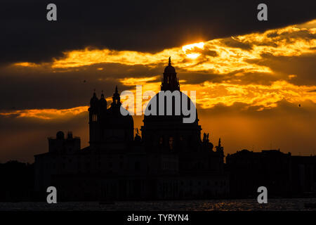 Geheimnisvoll und beautiufl Sonnenuntergang über Salute Basilika (Saint Mary für Gesundheit) alten Kuppeln in Venedig Stockfoto