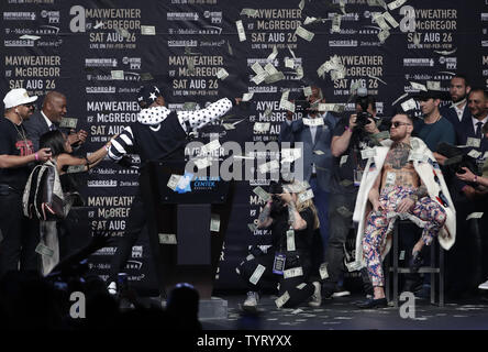 Fighter Floyd Mayweather Jr. (L) mit Geld zugedeckt Fighter Conor McGregor auf der Bühne als sie Worte Exchange auf einer Tour Nachrichten Konferenz an Barclays Center am 13. Juli 2017 in New York City. Die beiden werden in einem Boxkampf in Las Vegas auf dem 26. August, 2017 kämpfen. Foto von Jason Szenes/UPI Stockfoto