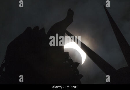 Eine partielle Sonnenfinsternis bewegt sich über den Himmel in der Nähe der Krone und der Fackel der Freiheitsstatue auf Liberty Island am 21. August 2017 in New York City. Heute ist die lange erwartete total Solar den Himmel aus Oregon darked Eclipse in South Carolina wie der Mond zwischen Erde und Sonne. Das letzte Mal die aneinandergrenzenden Staaten der USA sah eine totale Sonnenfinsternis 1979 war, und der nächste wird nicht bis 2024. Foto von John angelillo/UPI Stockfoto