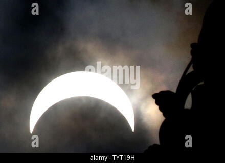 Eine partielle Sonnenfinsternis bewegt sich über den Himmel in der Nähe der Fackel der Freiheitsstatue auf Liberty Island am 21. August 2017 in New York City. Heute ist die lange erwartete Sonnenfinsternis wird der Himmel von Oregon abgedunkelten in South Carolina wie der Mond zwischen Erde und Sonne. Das letzte Mal die aneinandergrenzenden Staaten der USA sah eine totale Sonnenfinsternis 1979 war, und der nächste wird nicht bis 2024. Foto von John angelillo/UPI Stockfoto