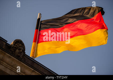 Berlin, Deutschland. 26 Juni, 2019. Eine deutsche Flagge schwebt über dem Dach des Reichstages. Credit: Lisa Ducret/dpa/Alamy leben Nachrichten Stockfoto