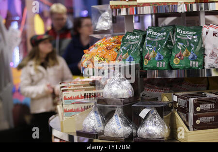 Käufer Spaziergang durch eine neue Hershey Store, das mit den Hershey's Chocolate World Attraktion stellt eine sensorische Erfahrung Grand Opening am Times Square in New York City am 14. Dezember 2017. Der Hershey Chocolate World Attraktion wird eine übergroße Hershey's Kisses "Plume" schneiden, Hershey's Geschmolzene Schokolade Toast und ein besonderes Geschenk für die ersten 1.000 Teilnehmer. Foto von John angelillo/UPI Stockfoto