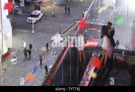 Ein Paar bleibt draußen auf dem Balkon mit einem fast leeren Times Square unten nach Mitternacht auf Silvester in New York City am 1. Januar 2018. Die Temperaturen werden in der Teens als schätzungsweise eine Million Menschen werden in Times Square Silvester und über eine Milliarde wird sein Ansehen in der Welt als die traditionellen Waterford Crystal Ball drop Salzen in 2018. Foto von John angelillo/UPI Stockfoto