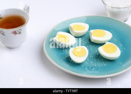 Scheiben gekochte Eier mit Tasse Tee Stockfoto