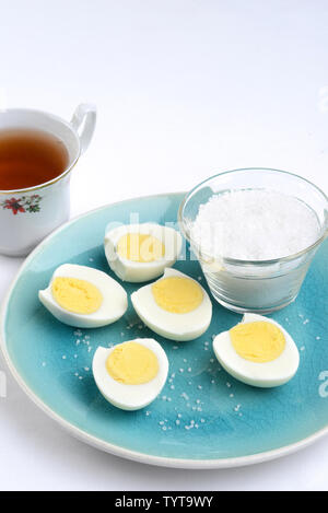 Gekochte Eier in Scheiben geschnitten, mit Salz Stockfoto