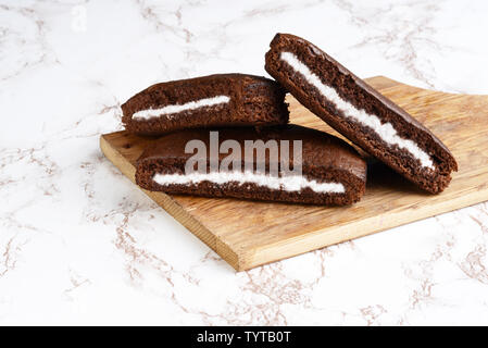 Drei Scheiben Schokoladencreme Kuchen auf Schneidebrett Stockfoto