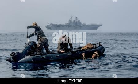 Am Meer, im Indischen Ozean (Nov. 28, 2016) Marines mit dem Maritimen Raid Kraft erhalten in einem Kampf Gummi Streifzüge Handwerk nach dem Sprung in den Ozean aus der CH-53E Super Stallion während einer helocast Ausbildung Evolution in der Nähe der USS Makin Island (LHD 8) flott in den Indischen Ozean. Mit einem Crrc ermöglicht Aufklärung Teams schnell und leise Einfügen auf einen Brückenkopf. Die Marines sind mit der 11 Marine Expeditionary Unit. Stockfoto