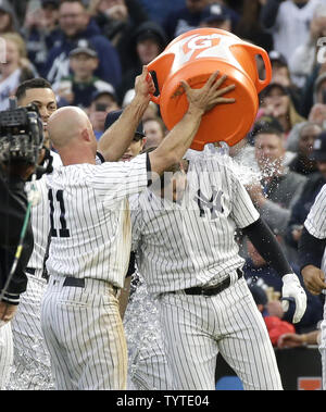 New York Yankees Brett Gardner dumps einen Eimer Wasser auf Neil Walker nach dem Walker eine gehen weg von den gewinnenden RBI, die in der elften Inning gegen die Oakland Athletics im Yankee Stadium in New York City am 12. Mai 2018 Hits. Die Yankees besiegten die Leichtathletik 7-6. Foto von John angelillo/UPI Stockfoto