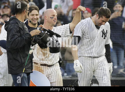 New York Yankees Brett Gardner dumps einen Eimer Wasser auf Neil Walker nach dem Walker eine gehen weg von den gewinnenden RBI, die in der elften Inning gegen die Oakland Athletics im Yankee Stadium in New York City am 12. Mai 2018 Hits. Die Yankees besiegten die Leichtathletik 7-6. Foto von John angelillo/UPI Stockfoto