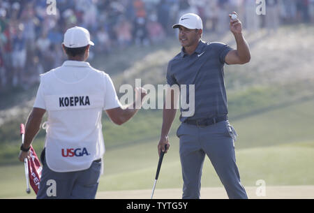 Bäche Koepka und caddie Richard Elliot feiern auf der 18 nach dem Gewinn der 118 U.S. Open Championship in Shinnecock Hills Golf Club in Southampton, New York am 17. Juni 2018. Koepka gewann die Meisterschaft mit einer Punktzahl von 1 über Par Tommy Fleetwood aus England werden nur die sechste Spieler bis 63 in einem U.S. Open schießen. Foto von John angelillo/UPI Stockfoto