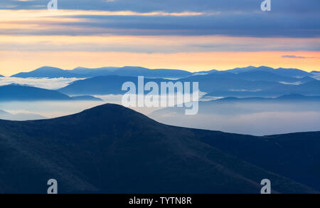 Blue Mountain Silhouetten am Morgen. Alpine Landschaft von oben auf einem Hügel Stockfoto