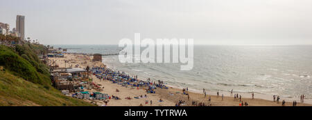 Tel Aviv, Israel - 13. April 2019: Schöne Aussicht auf einem überfüllten Strand in einer modernen Stadt während einer bewölkt und sonnig. Stockfoto