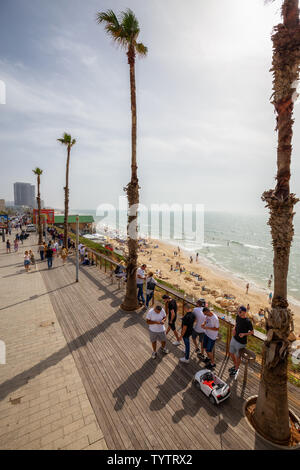 Tel Aviv, Israel - 13. April 2019: Schöne Aussicht auf einem überfüllten Strand in einer modernen Stadt während einer bewölkt und sonnig. Stockfoto