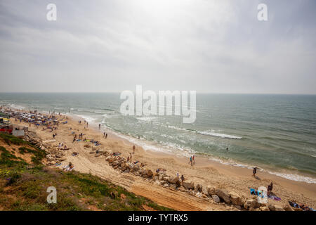 Tel Aviv, Israel - 13. April 2019: Schöne Aussicht auf einem überfüllten Strand in einer modernen Stadt während einer bewölkt und sonnig. Stockfoto