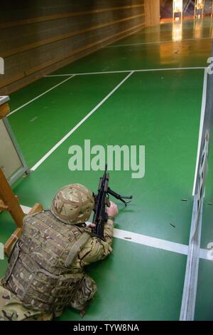 Ein Mitglied der Britischen Streitkräfte stellt sicher, dass seine L 85 A2 Gewehr entladen an der Schulung Support Center Benelux 25 m Reichweite im Innenbereich, auf chièvres Air Base, Belgien, November 30, 2016. Die britischen Truppen unter Aufsicht der britischen Joint European Training Team ausgebildet. Stockfoto