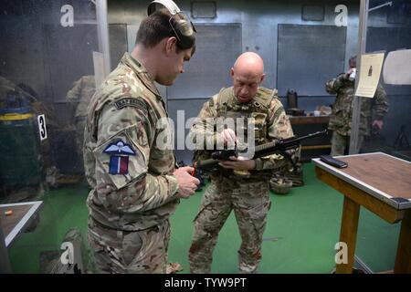 Royal Air Forces Mitglied (Ausbilder) der Gemeinsamen Europäischen Training Team, die Zeroing" Waffe der britischen Soldaten zu den lokalen Einheiten während der L 85 A2 rifle Kalibrierung bei der Schulung Support Center Benelux 25 m-Indoor Bereich zugewiesen überwacht, in Chièvres Air Base, Belgien, November 30, 2016. Die britischen Truppen unter Aufsicht der britischen Joint European Training Team geschult Stockfoto