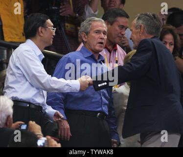 Ehemaliger Präsident Bush schüttelt Hände mit dem chinesischen Außenminister Yang Jiechi als Präsident George Bush mit ihm spricht, wie sie die USA gegen China Basketball Spiel bei den Olympischen Spielen 2008 in Peking am 10. August 2008 ein. (UPI Foto/Terry Schmitt) Stockfoto