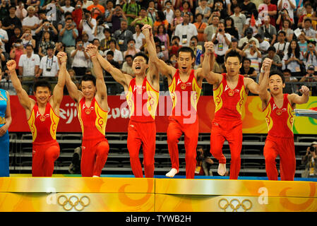 Die chinesischen Männer Gymnastik Team melden Sie Hände und auf die Bühne führen ihre Goldmedaillen nach dem Gewinn der Männer Team Finale, an der National Indoor Stadium, 12. August 2008 zu erhalten, bei den Olympischen Sommerspielen in Peking, China. (L - R) Chen Yibing, Huang Xu, Li Xiaopeng, Xiao Qin, Yang Wei und Zou Kai. Der Japaner gewann den Silbernen und den USA die Bronze gewann. (UPI Foto/Mike Theiler) Stockfoto