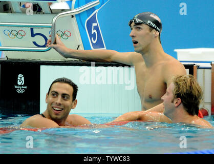 Die USA Michael Phelps und Serbiens Milorad Cavic (L) Blick auf die Anzeigetafel, wo es zeigt Phelps gewann die Goldmedaille bei den Herren 100 Meter Schmetterling Finale bei den National Aquatics Center bei den Olympischen Sommerspielen in Peking am 16. August 2008. Phelps gewann seine siebte Goldmedaille der Spiele einen weiteren Weltrekord von 50.58 und Cavic gewann das Silber - nur 0,01 Sekunden hinter sich. Auf der rechten Seite ist die USA Ian Crocker, Vierter. (UPI Foto/Pat Benic) Stockfoto