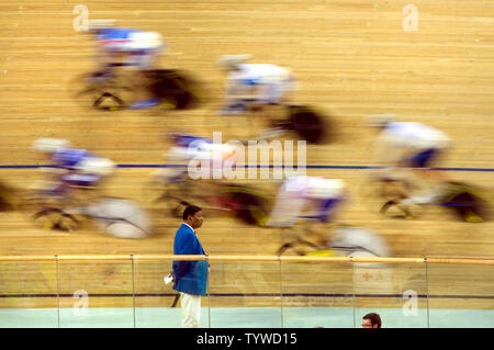 Ein streckenposten Uhren als Radfahrer sprint während der 100-race's Lap olympischen Frauen punkt Endrunde an der Laoshan Velodrom in Peking am 18. August 2008. Niederländische Radfahrer Marianne Vos das Gold mit 30 Punkten, Kubas Yoanka Gonzalez das Silber mit 18 Punkten und dem Spanischen Leire Sanxenxo die Bronze mit 13 Punkten erfasst. (UPI Foto/Stephen Rasierer) Stockfoto